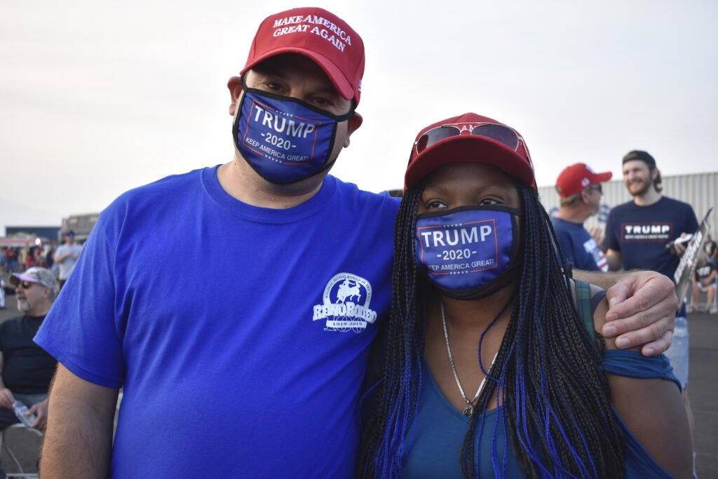 Steve Lopez (left) and Keri Barnes (right) are wearing "Make America Great Again" hats and "Trump 2020" face masks. 