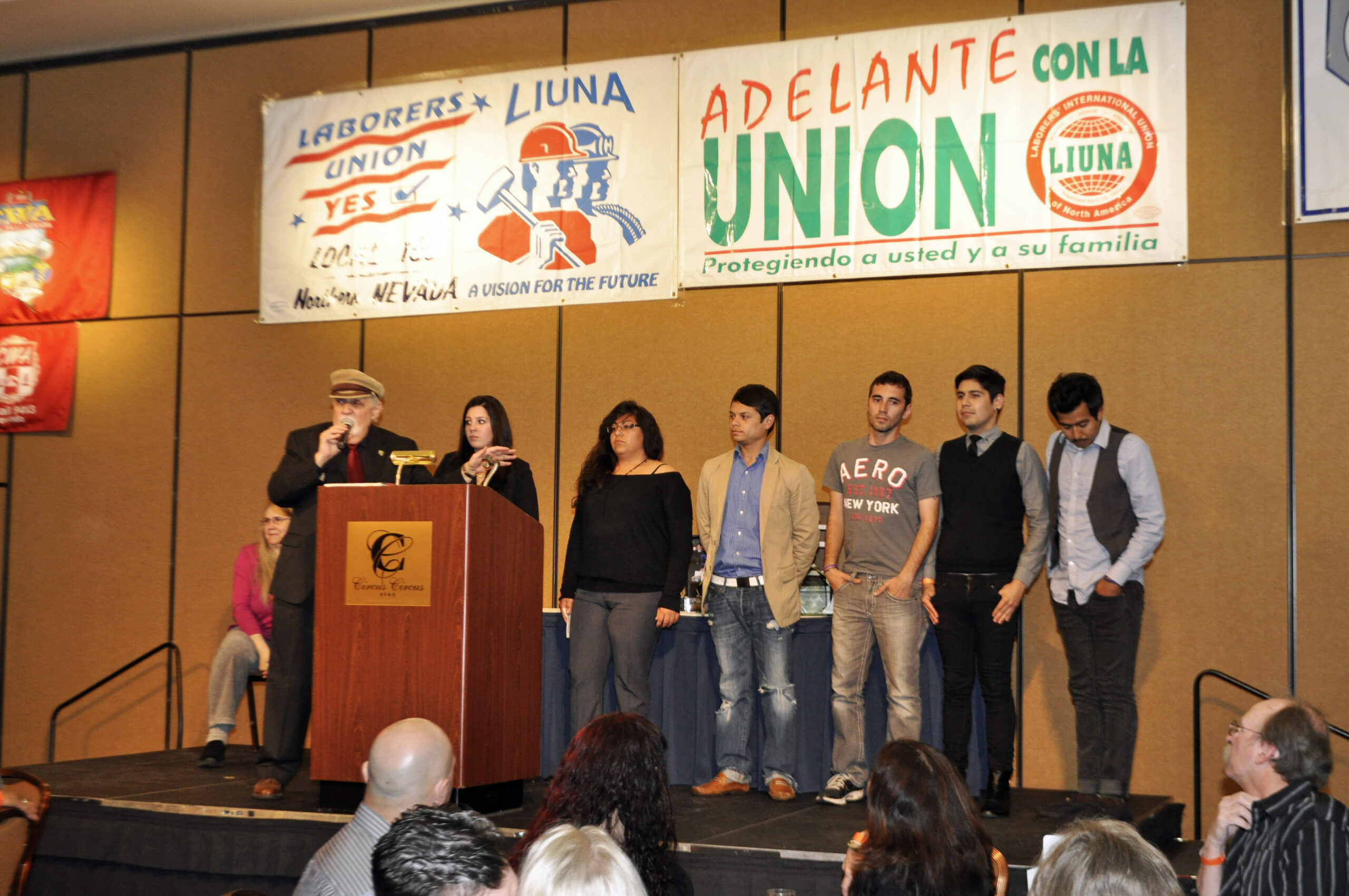 Students on stage with union banners behind them