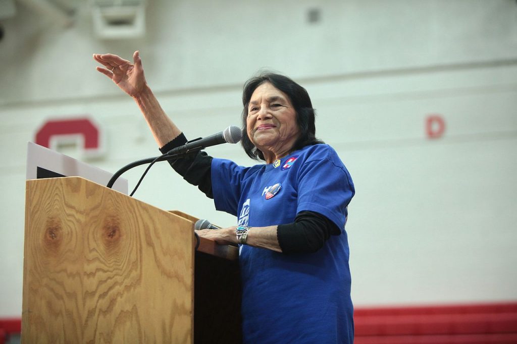 Dolores Huerta waves from podium