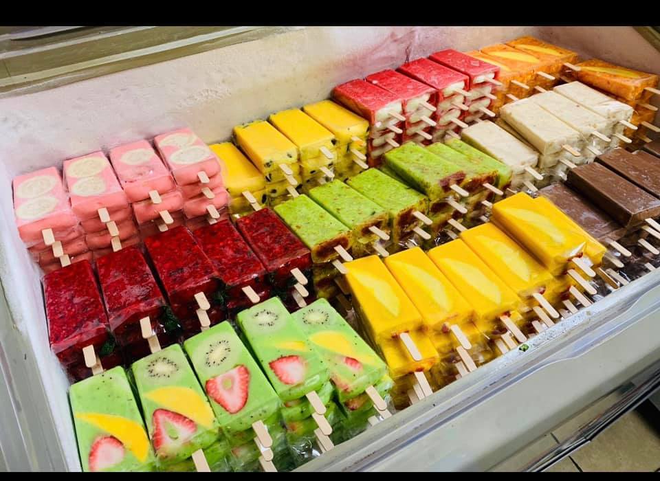 stacks of colorful paletas in refrigerator