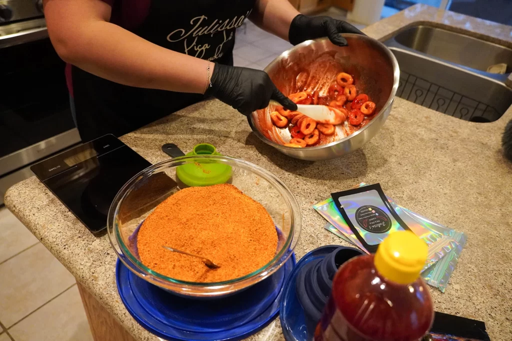 Pictured are someone mixing gummies and a bowl of powdered chamoy