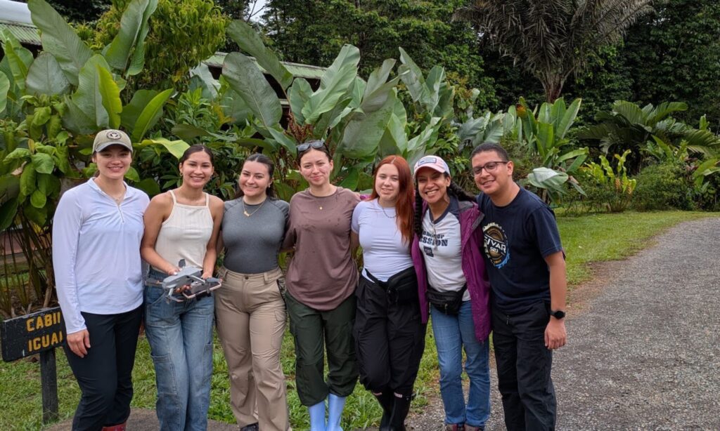 seven people pose in jungle