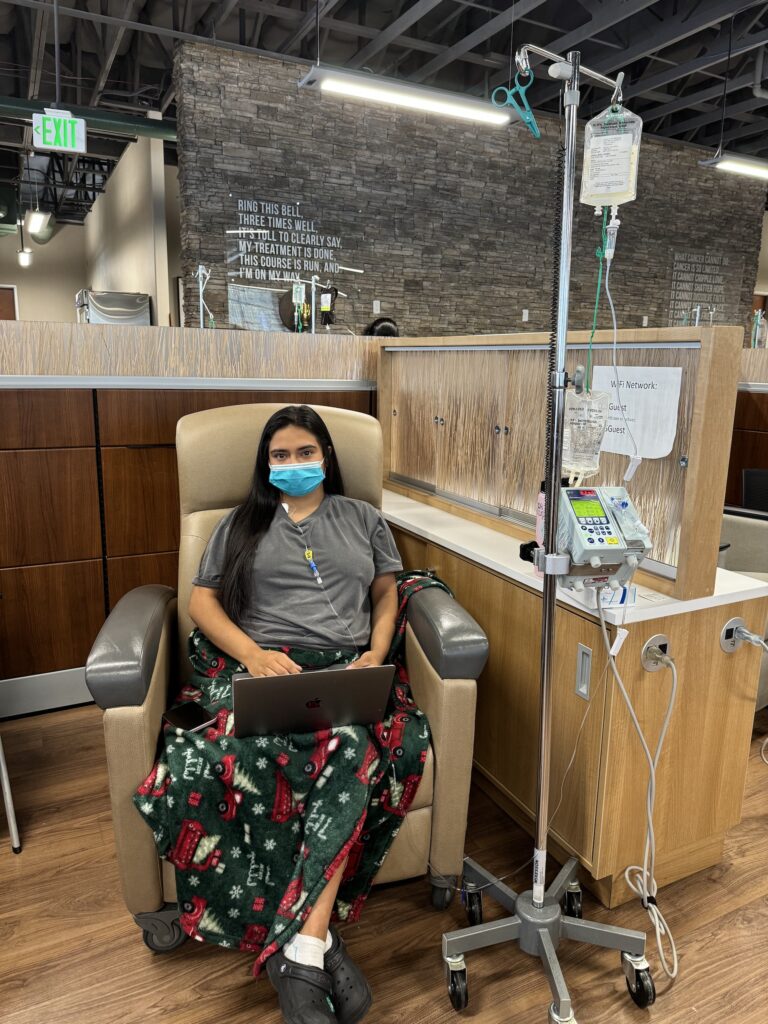 Young woman seated with medical devices and mouth mask