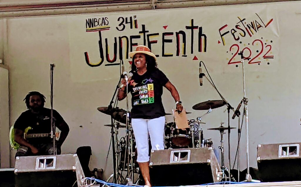 woman on stage speaks into microphone