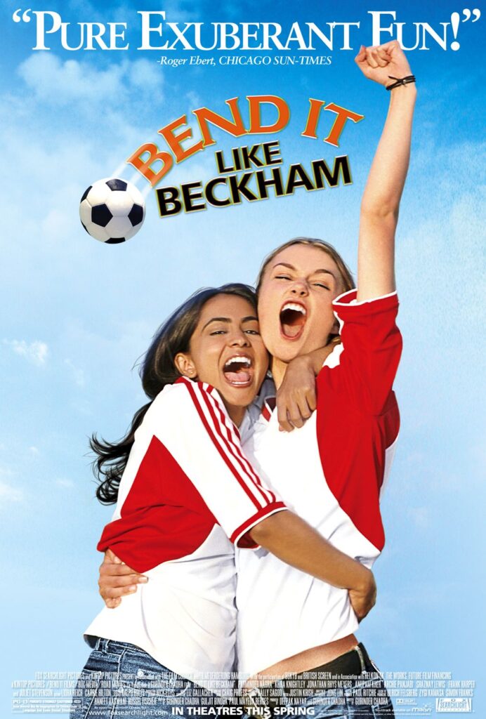 two girls cheer as soccer balls flies over them