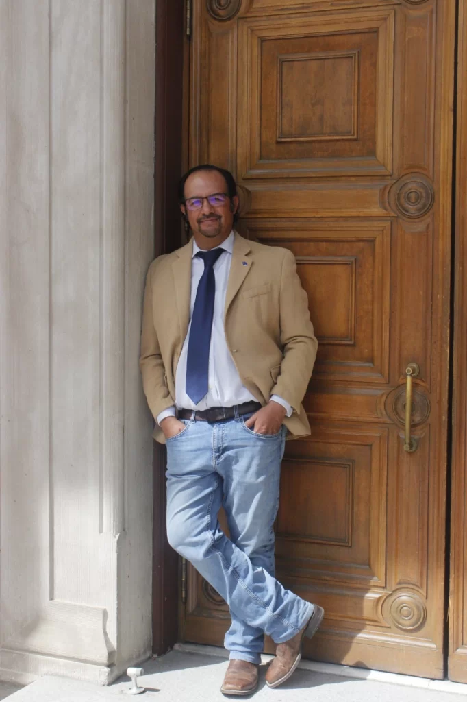 Man standing by doorway, posing and smiling for a photo