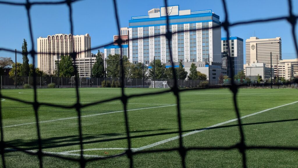 sports field with a hotel behind it