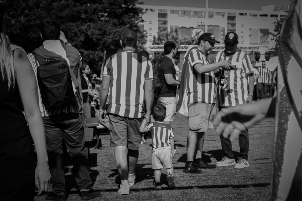 dad and son walk with their Paraguay jerseys on [black and white photo]