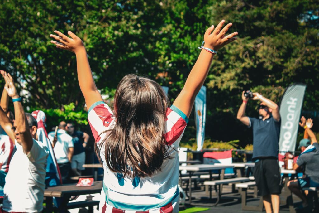 little girl throws hands in air in celebration
