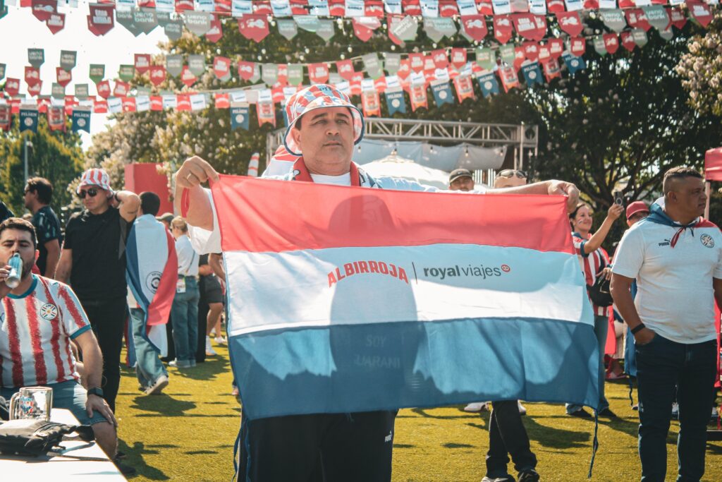 man holds red, white and blue flag of Paraguay