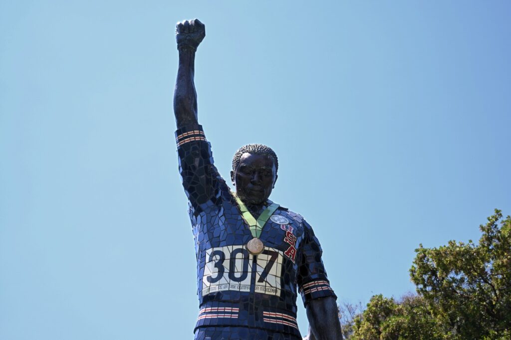 three statues of Olympic athletes on medal the stand