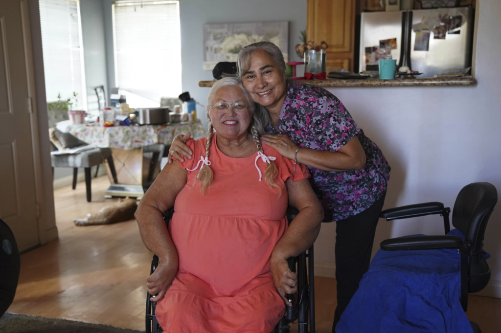 two women embracing looking at camera