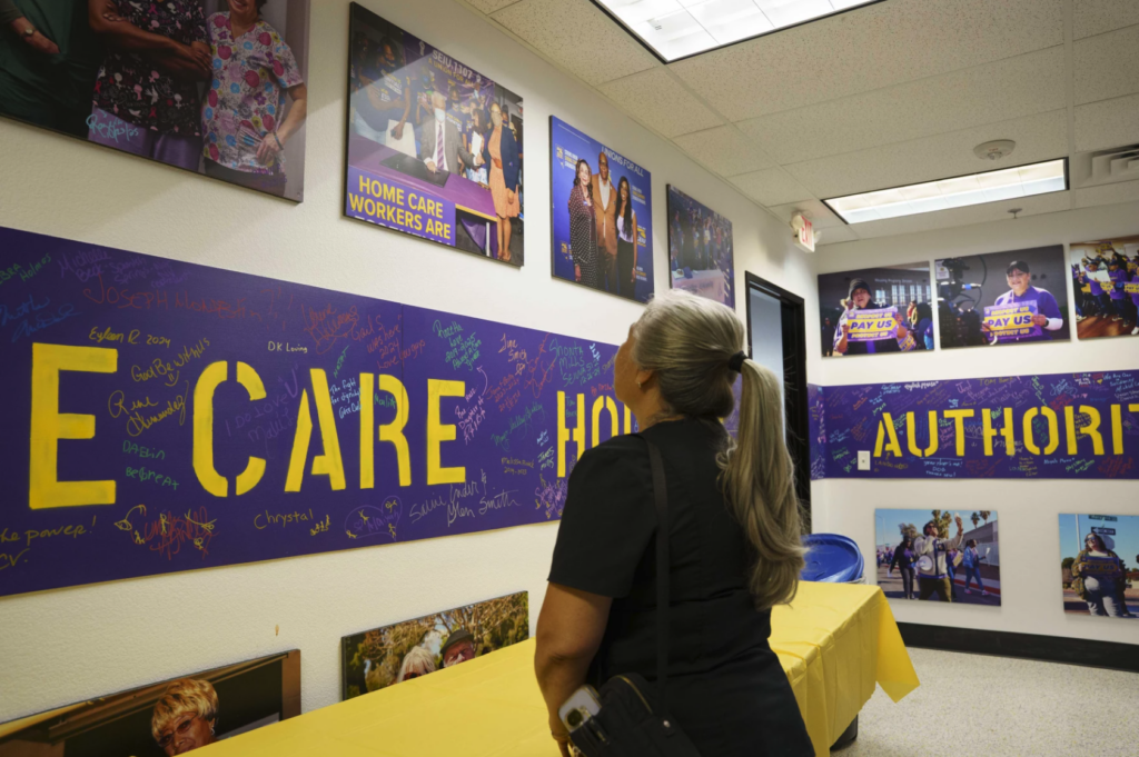 woman looks at photos on wall