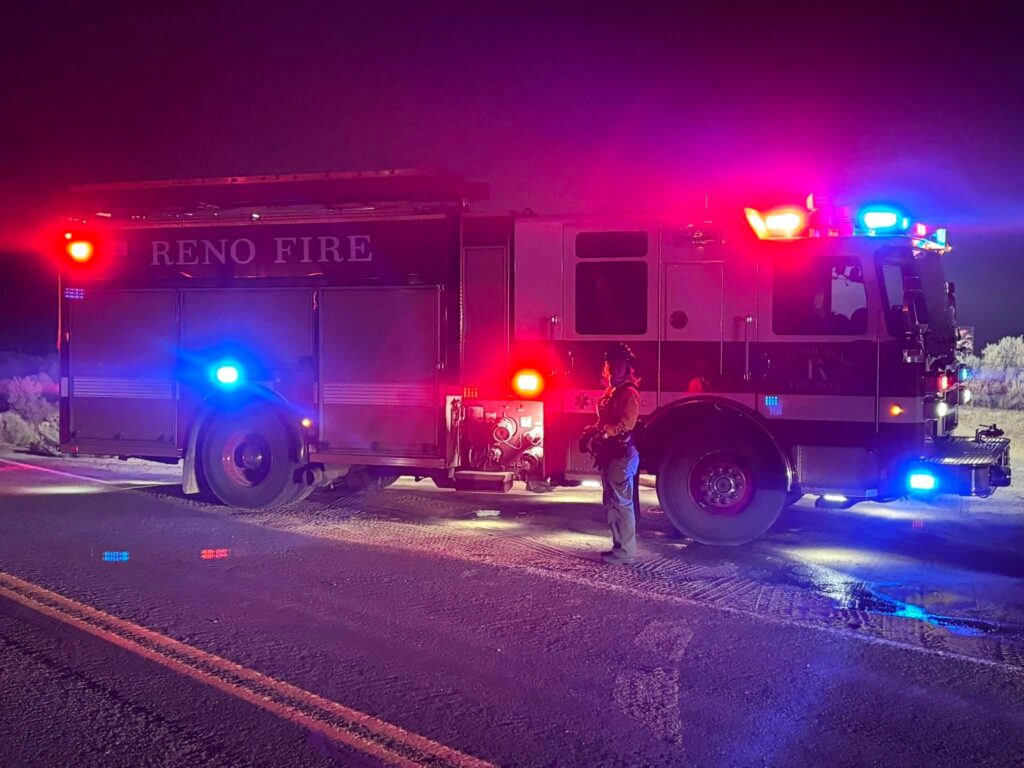 firefighter stands in front of truck