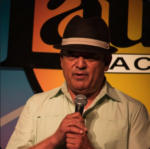 man with hat speaks into microphone