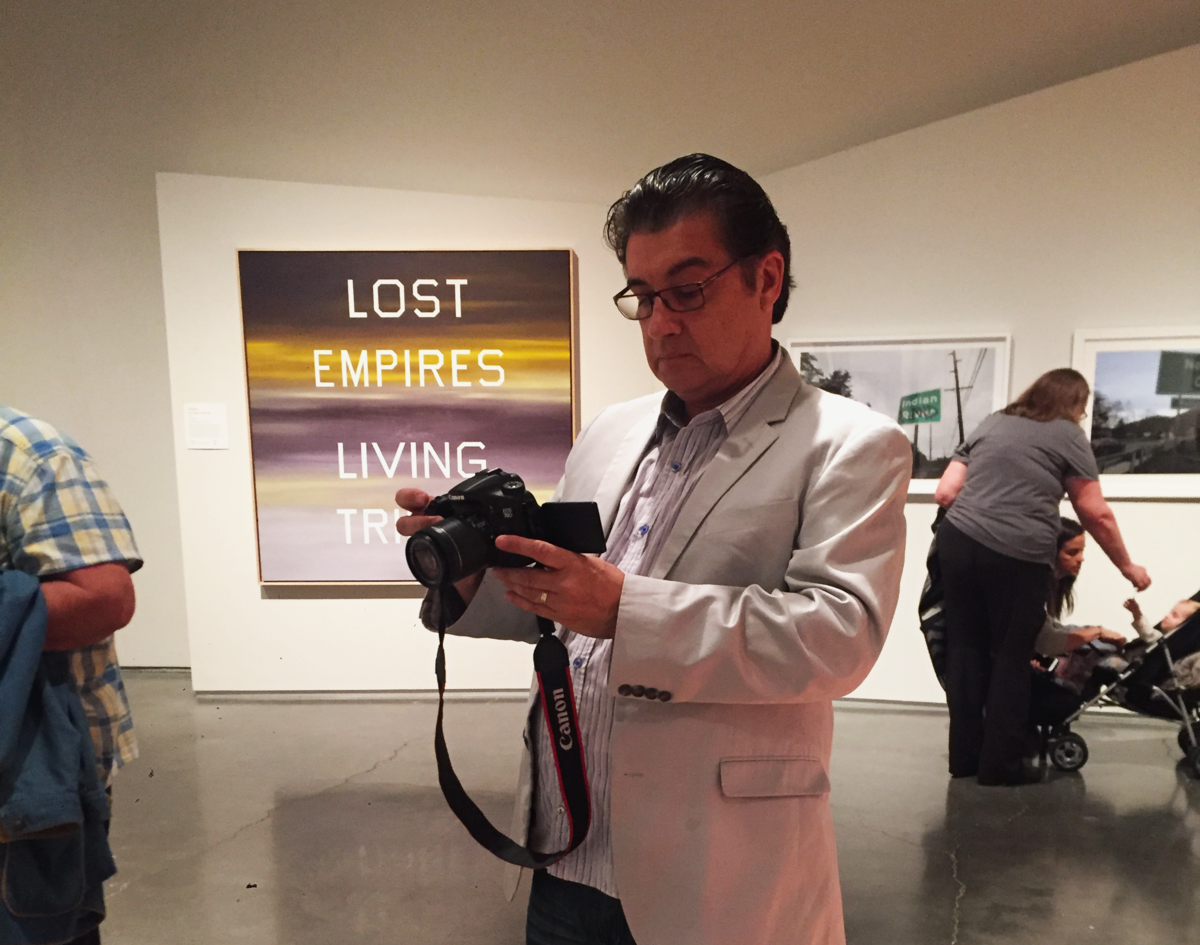 Guillermo Bert proudly takes pictures of his pieces displayed in the exhibition, standing back and reviewing them carefully.