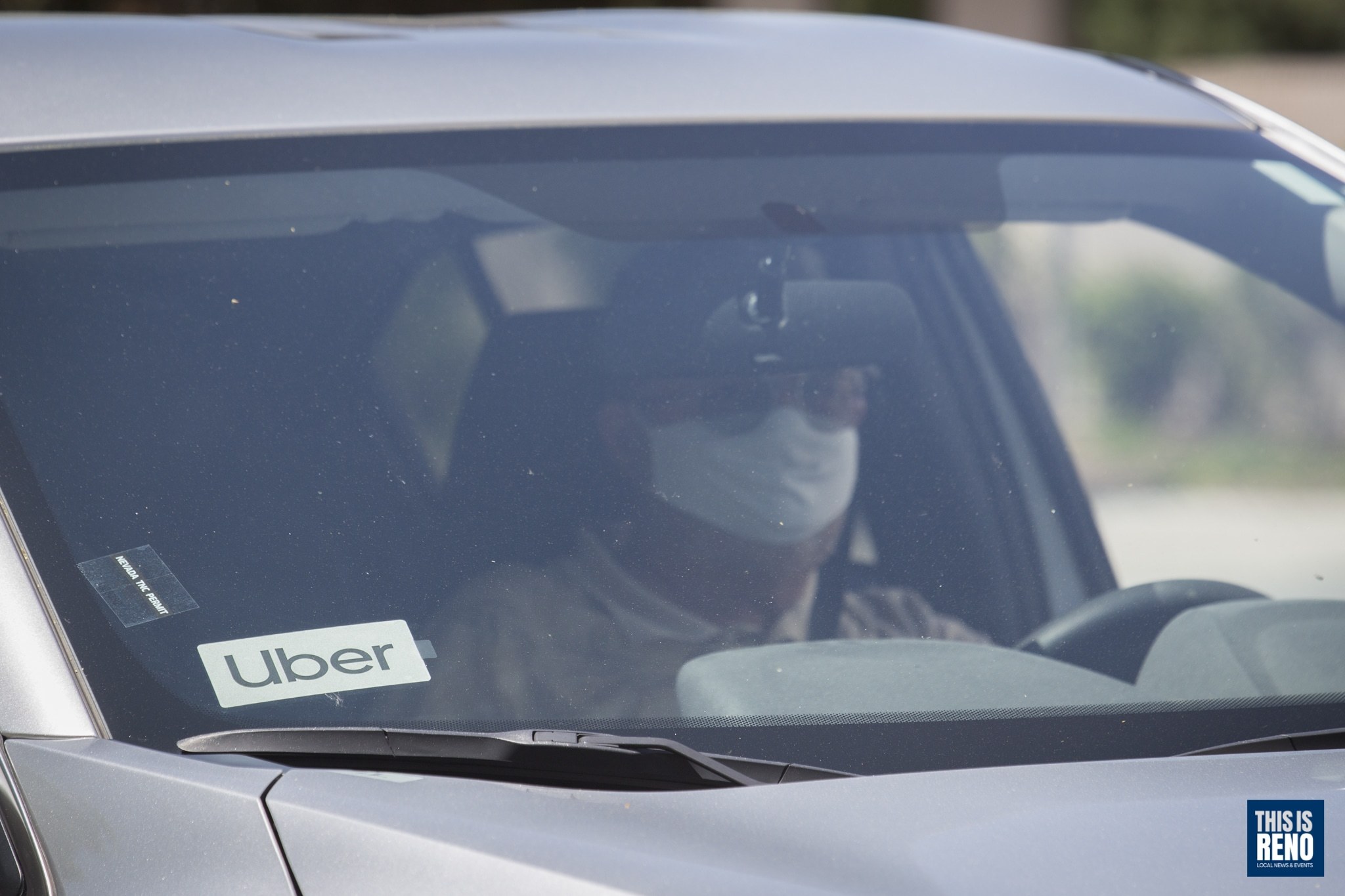 An Uber driver wearing a mask while working.
