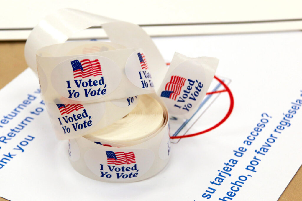 A large roll of “I voted” stickers sitting on top of a table.