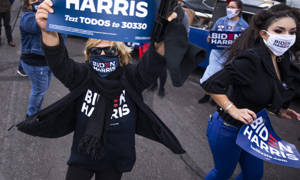 people with posters por Biden and Harris celebrate
