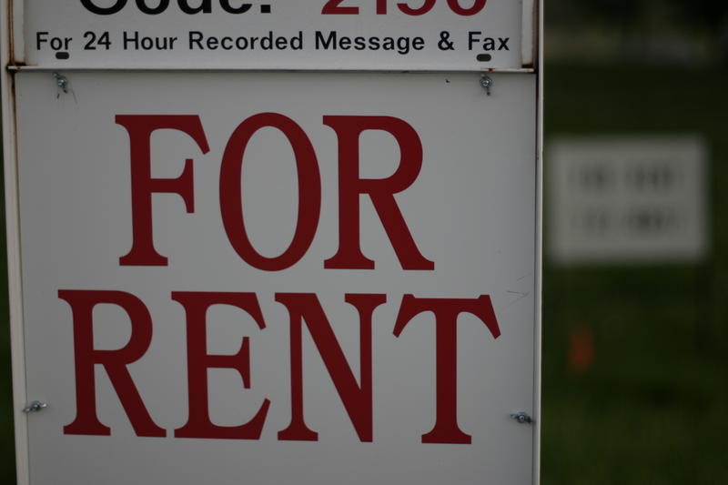 A white sign with "Rent" in bold red letters.