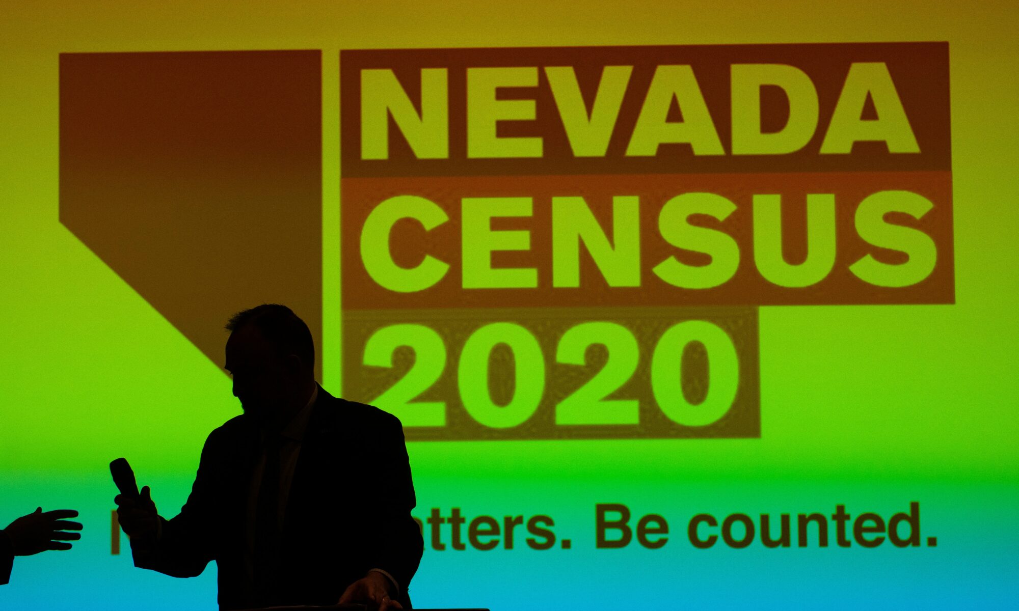A man posing in front of a screen that reads Nevada Census 2020