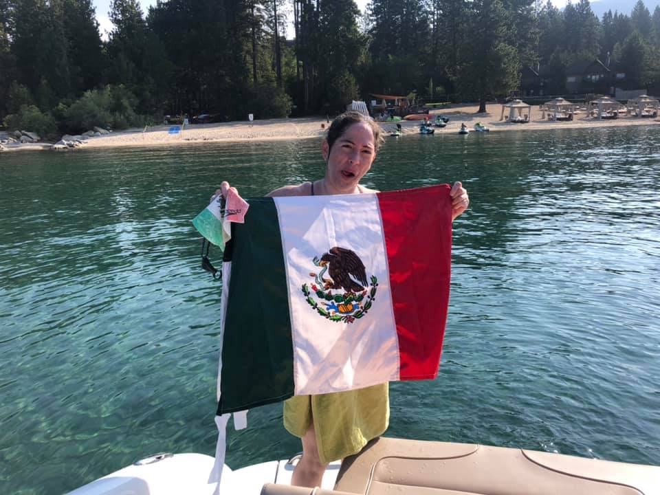 A woman holding a flag at a lake