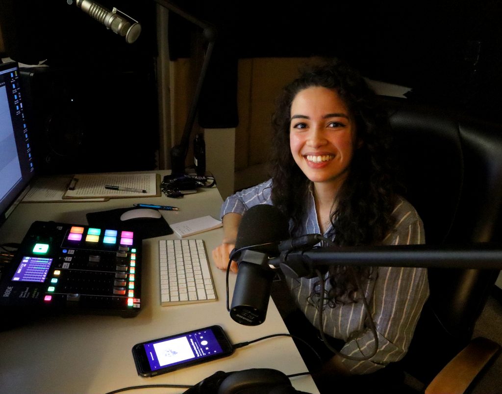 woman smiling seated in radio booth
