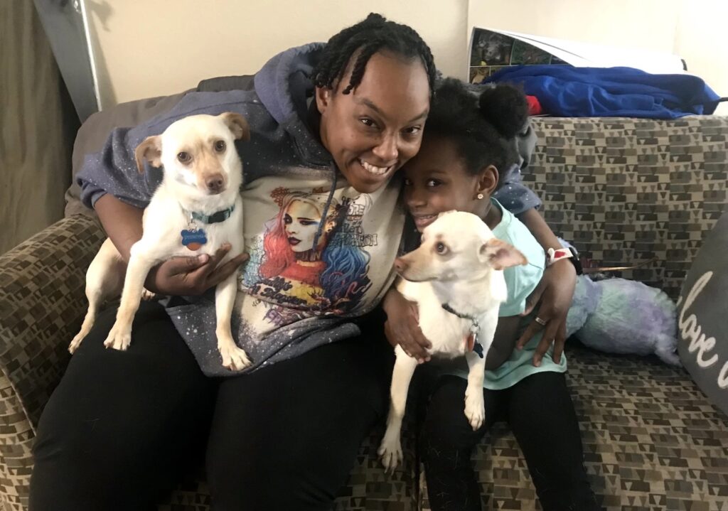 woman with daughter and two dogs on couch