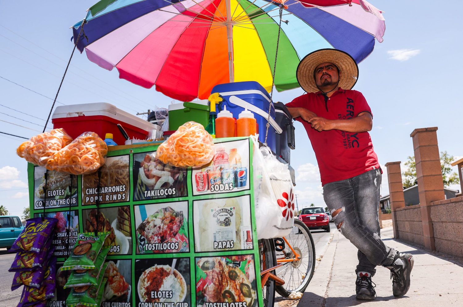 Man leans against street food cart