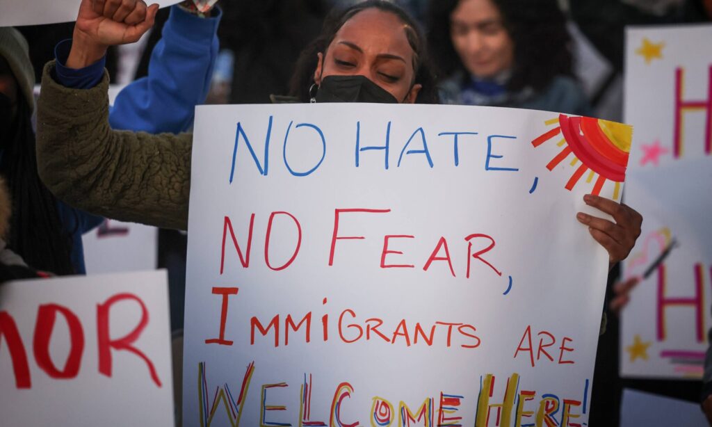 Woman at Immigration Rally with a sign that reads "No Hate, No Fear, Immigrants are welcome here"