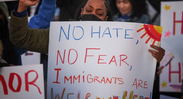 Woman at Immigration Rally with a sign that reads "No Hate, No Fear, Immigrants are welcome here"