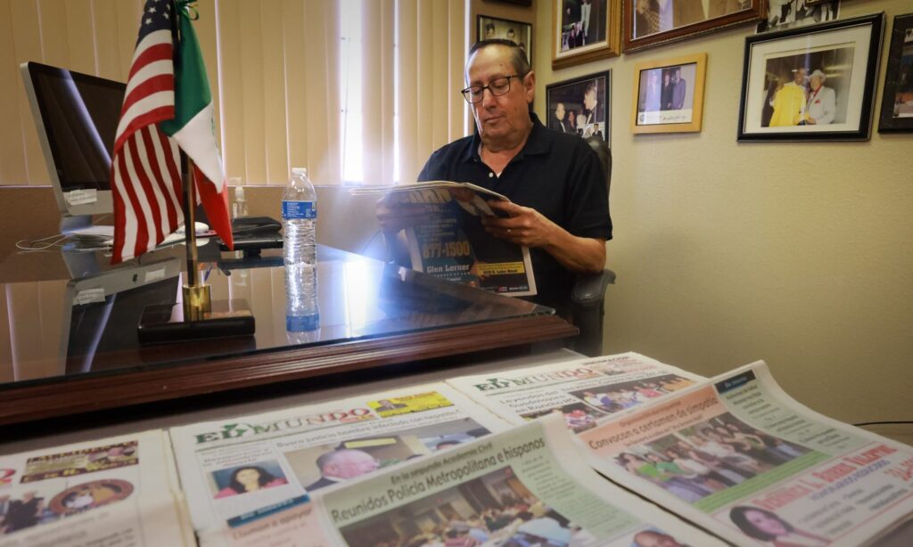 Eddie Escobedo Jr, reading the newspaper at his desk