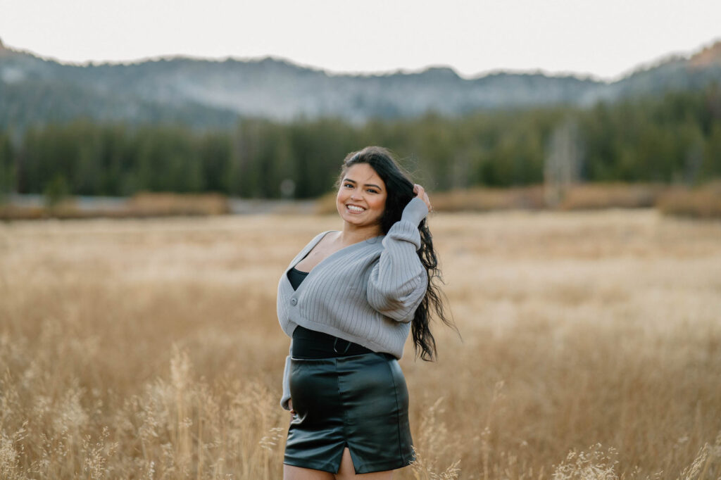 young smiling girl takes pose in landscape