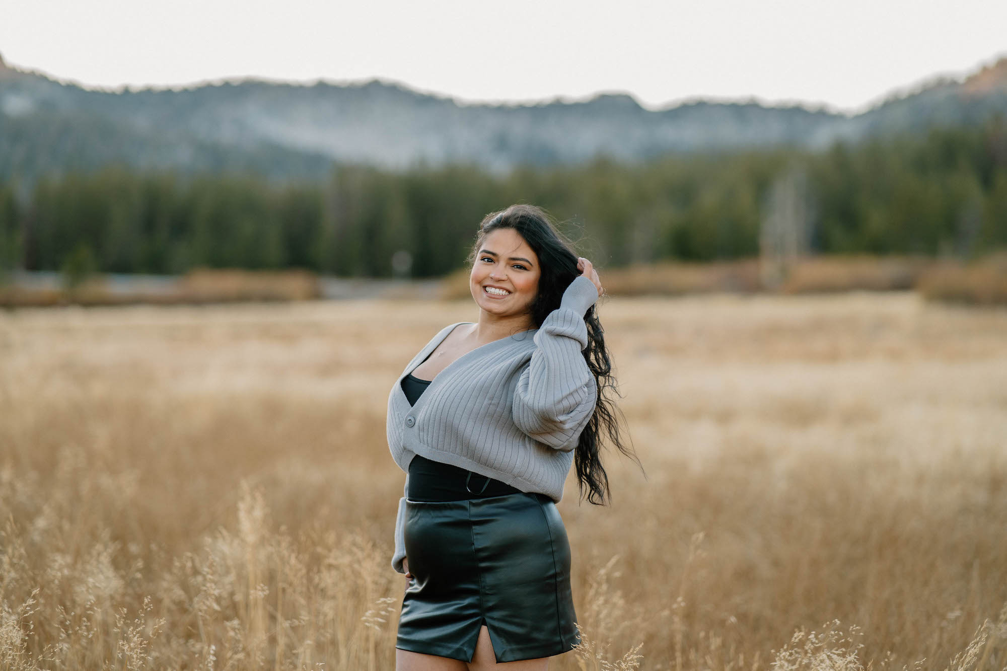 young smiling girl takes pose in landscape