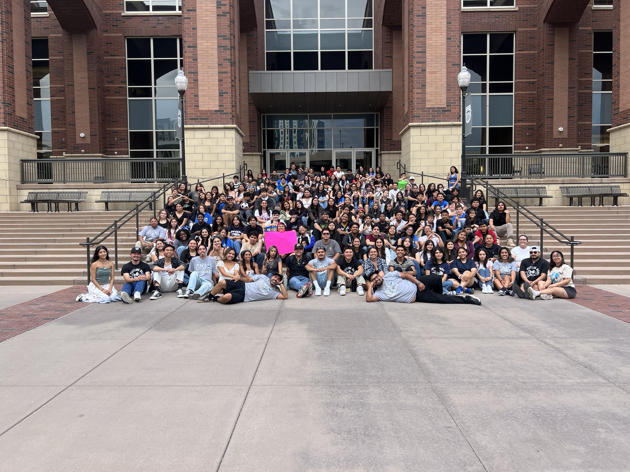 docenas de estudiantes posan para un foto sentados en escaleras