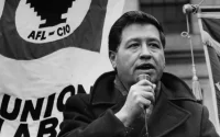 Cesar Chavez with a microphone in hand giving a speech at a rally
