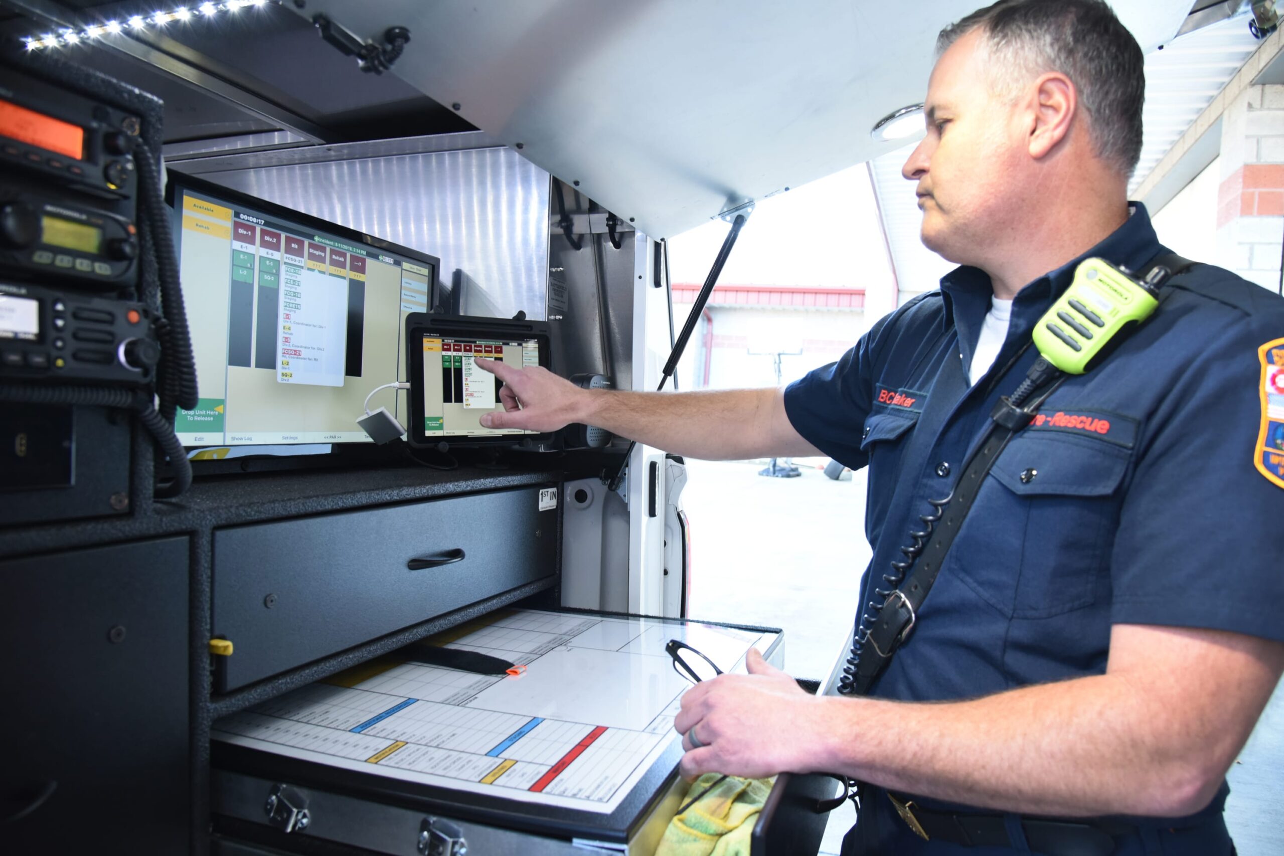 Firefighter pointing at information on fire engine's computer