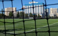 sports field with a hotel behind it