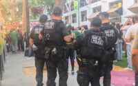 four san josé police officers look over a crowd