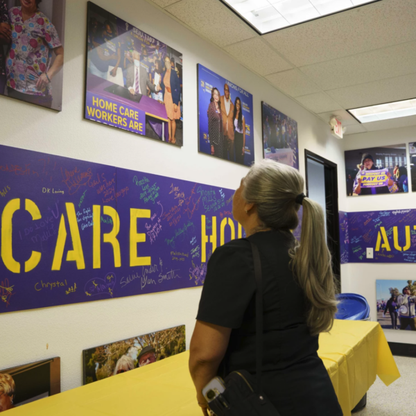 woman looks at photos on wall